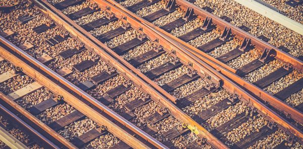 Rusty-hued closeup photograph of tracks running through a train yard